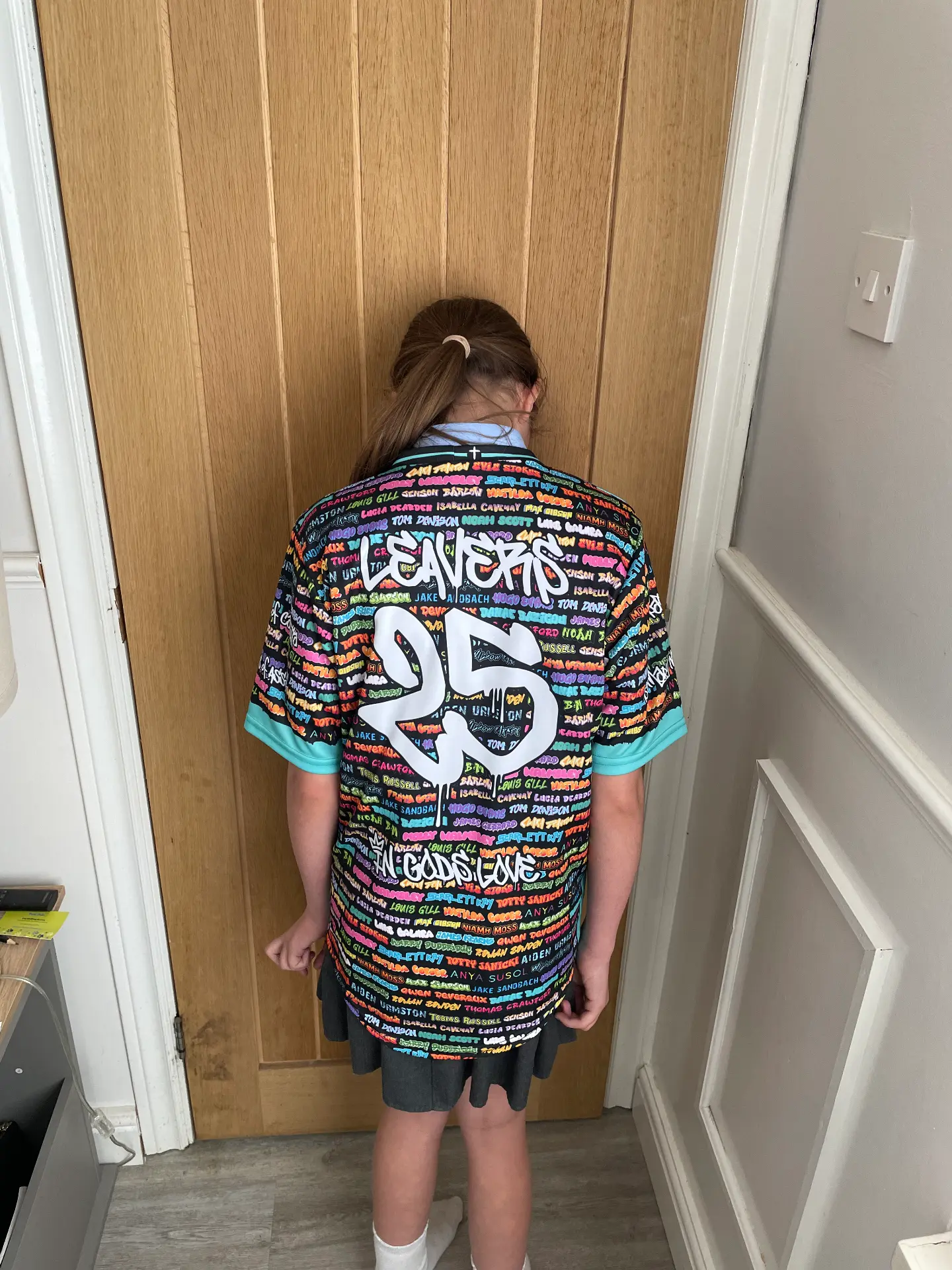 Back of a black 22 Unite leavers shirt printed with colourful names
