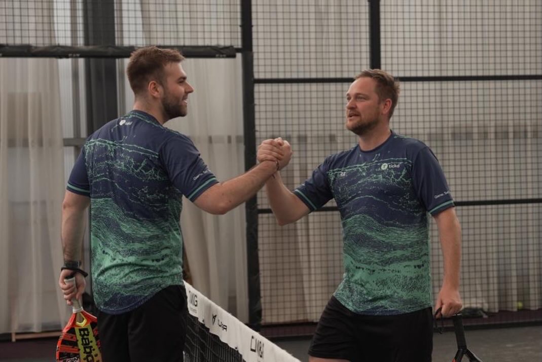 Players shaking hands at the net in 22 Unite shirts