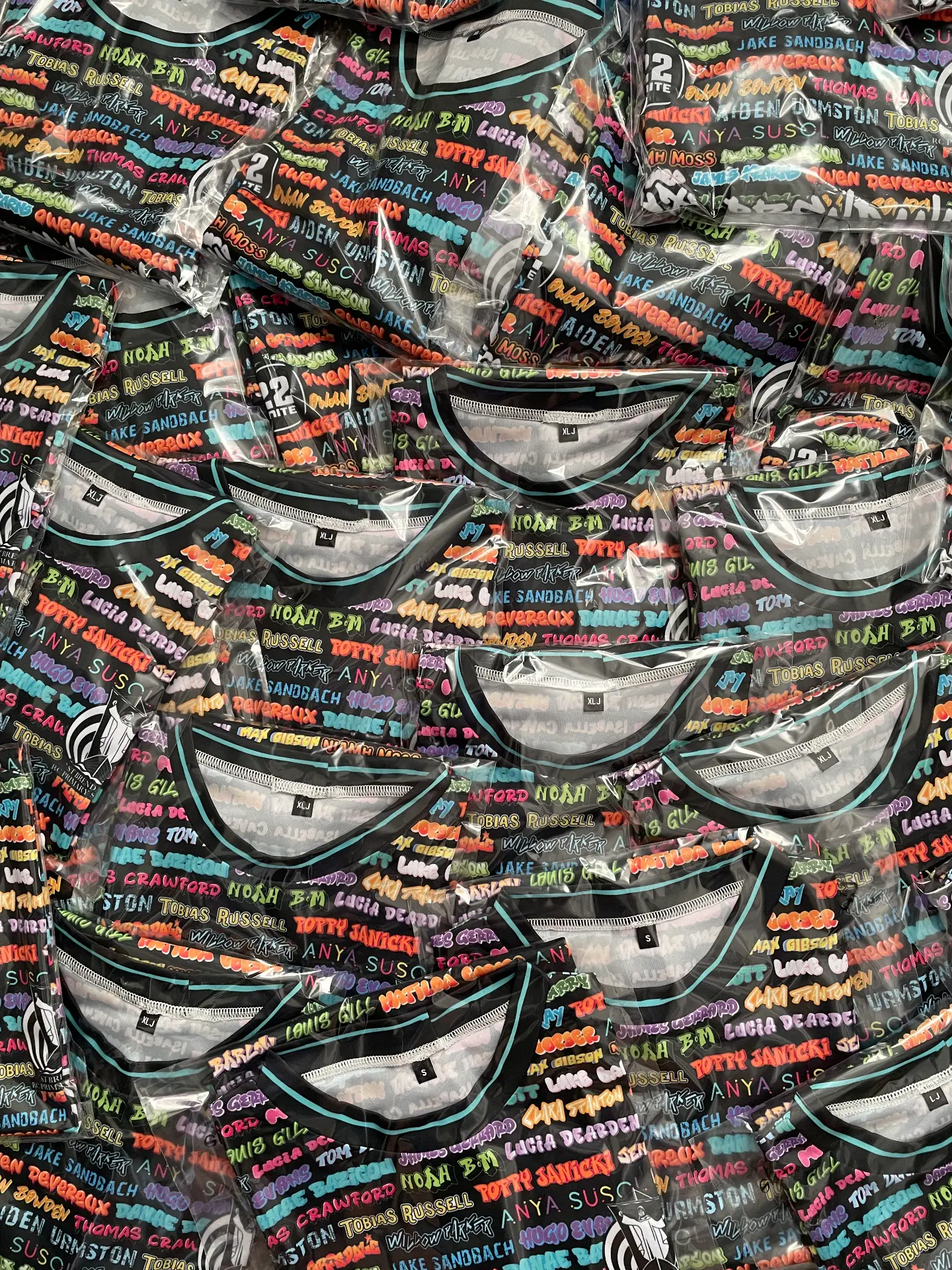 Folded black 22 Unite shirts printed with colourful names
