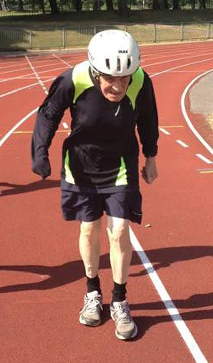 Malcolm Pittock on a running track wearing his white helmet